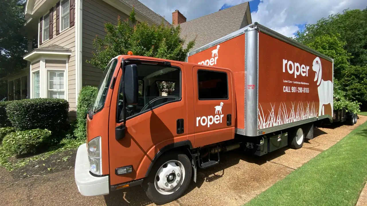 Orange Roper Lawn & Landscape box truck parked in a Memphis residential driveway